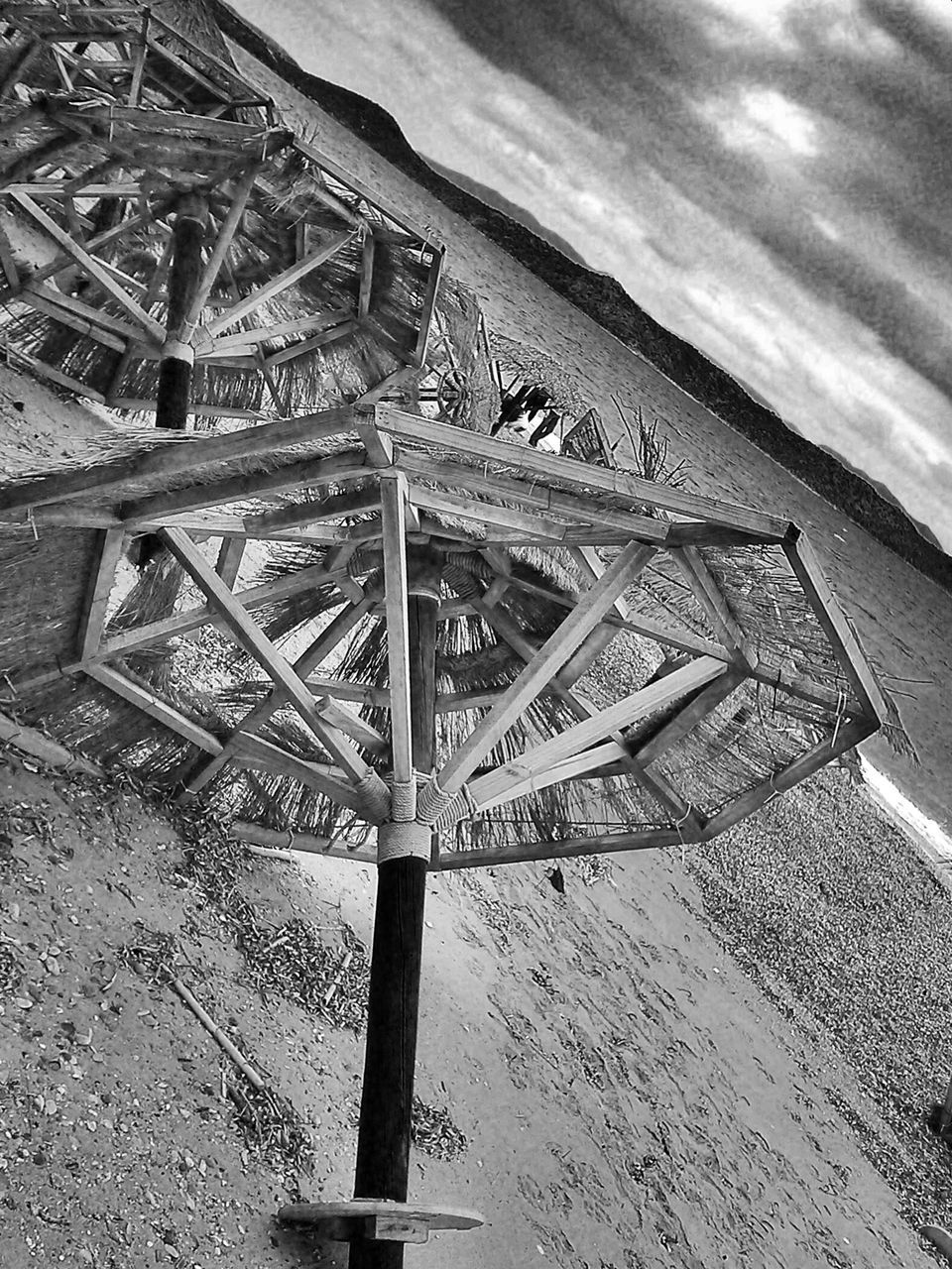 built structure, architecture, high angle view, sky, beach, day, building exterior, outdoors, no people, sunlight, nature, roof, tranquility, sand, wood - material, landscape, cloud - sky, absence, shadow, pattern