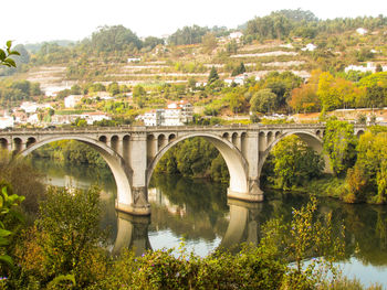 Arch bridge over river against sky