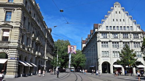 People on road amidst buildings in city