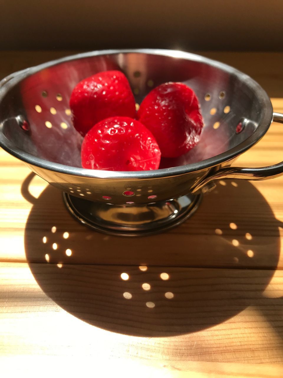 CLOSE-UP OF STRAWBERRIES IN PLATE ON TABLE