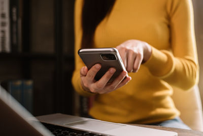 Midsection of man using mobile phone