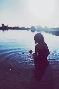 Rear view of man on lake against sky