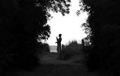 Rear view of silhouette man standing on field against sky