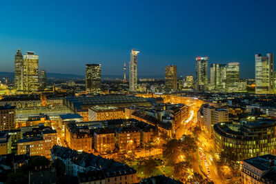 High angle view of illuminated buildings in city at dusk