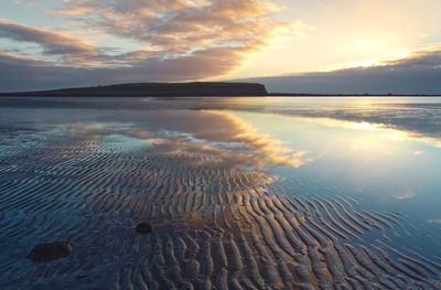  beach scape scenery with sandy beach,sky reflected in water at silverstrand in galway,ireland