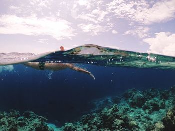 Water surface shot of man swimming in sea against sky