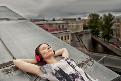 Portrait of smiling woman lying down in city