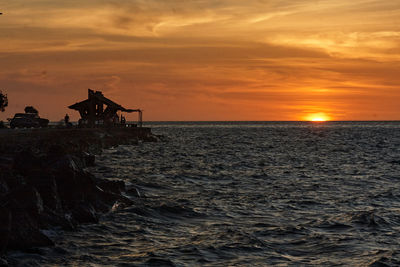 Scenic view of sea against orange sky