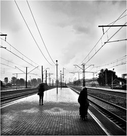 People walking on railroad tracks in city