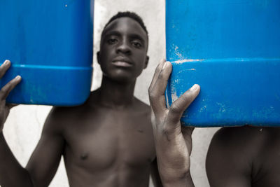 Portrait of shirtless man washing hands