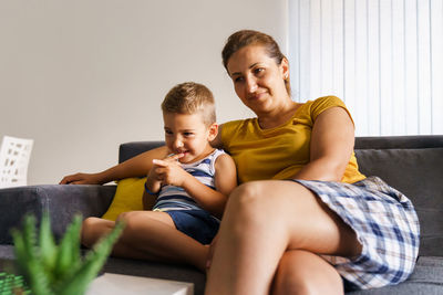 Boy sitting on sofa at home