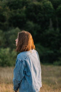 Rear view of woman standing on field