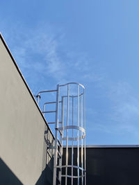 Low angle view of staircase against blue sky