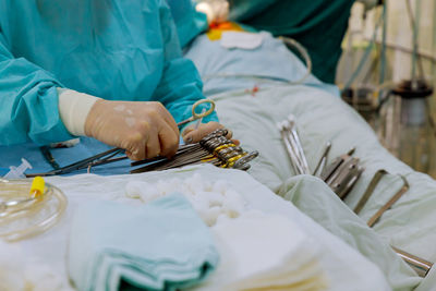 Midsection of doctor holding medical equipment in hospital