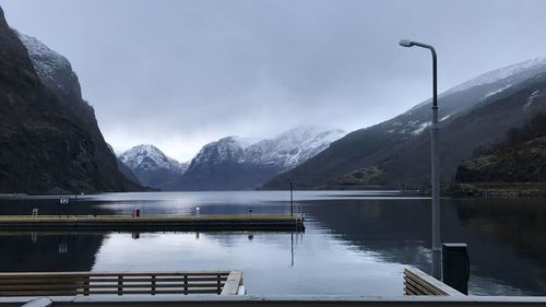 Scenic view of lake by snowcapped mountains against sky