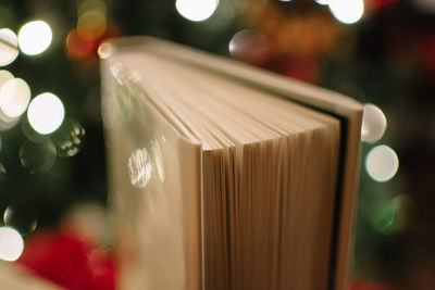 Close-up of book against illuminated lights