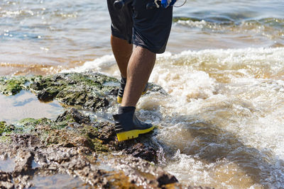 Low section of man standing in lake