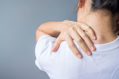 Close-up of hands making face against gray background