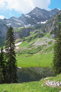 Scenic view of green landscape and mountains against sky