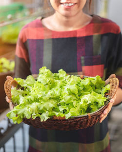 Midsection of woman holding ice cream in basket