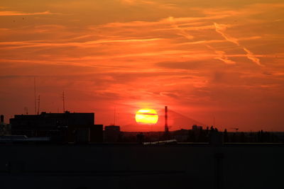 Silhouette buildings against sky during sunset