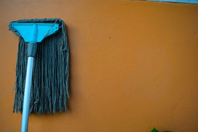 Blue mop on brown wall
