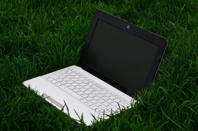 High angle view of laptop on grassy field