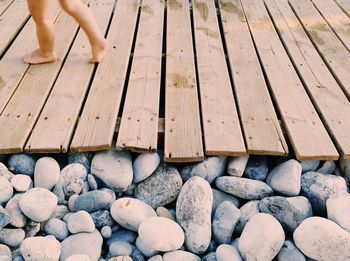 Low section of woman walking on wooden floor