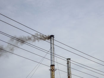 Low angle view of electricity pylon against sky