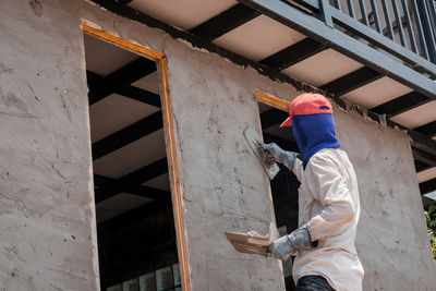 Low angle view of man working on building