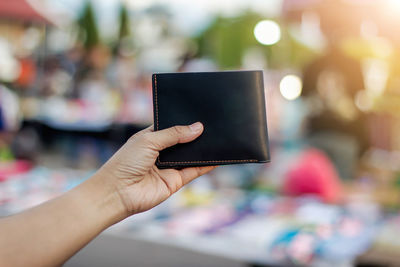 Close-up of woman holding wallet outdoors