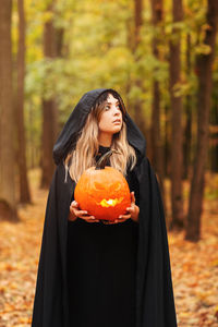 Young woman standing in a forest during autumn