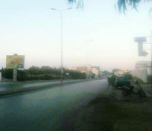 Vehicles on road against clear sky