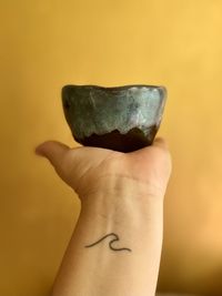 Cropped hand holding pottery