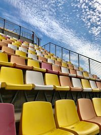 Empty chairs in stadium against sky