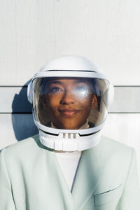 Young businesswoman day dreaming with space helmet