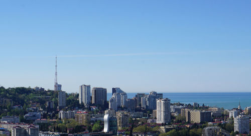 Modern buildings in city against clear blue sky