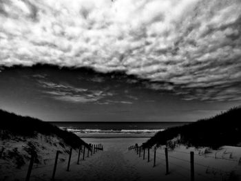 Scenic view of beach against sky at dusk