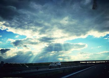 Highway against sky seen through car windshield