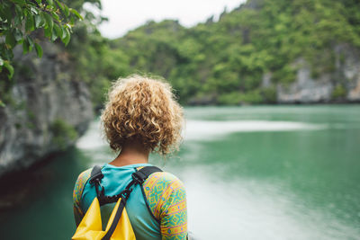 Rear view of woman standing by sea