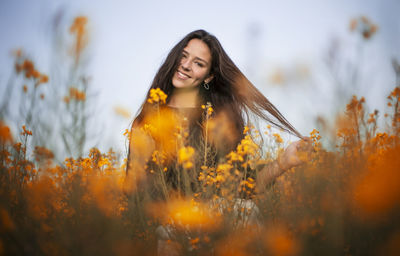 Portrait of smiling teenage girl by flowering plants