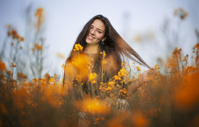 Woman standing on field against yellow sky