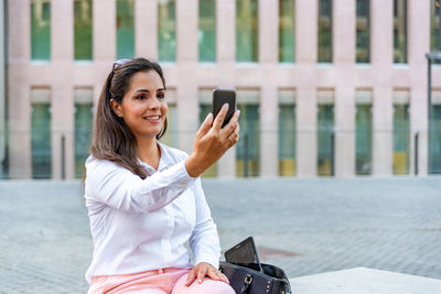 Caucasian mid adult businesswoman videocalling with mobile phone