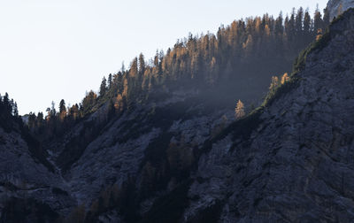 Low angle view of rocky mountains against clear sky