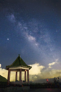 Low angle view of cross on building against sky at night