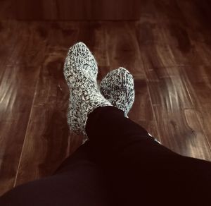 Low section of woman sitting on wooden floor