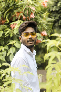 Portrait of young man wearing sunglasses standing outdoors