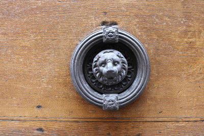 Close-up of door knocker on wooden wall