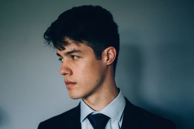 Close-up portrait of man against blue background