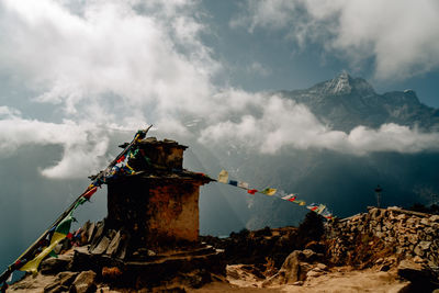 Traditional windmill on mountain against sky